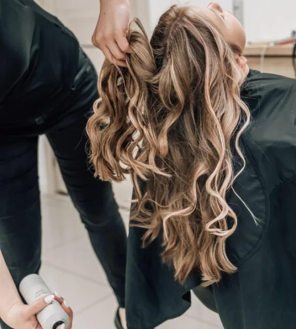 Estilista peinando una melena con ondas en Peluquería Doble T